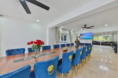 a large dining room with a long table and blue chairs at Marble Villa Prime Location in Hollywood