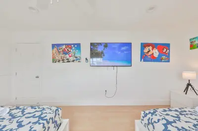 a bedroom with two beds and pictures on the wall at Haunted corner of Aventura Villa in Miami