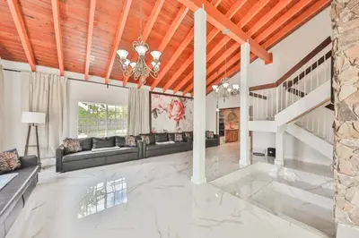 a living room with a couch and a staircase at Haunted corner of Aventura Villa in Miami