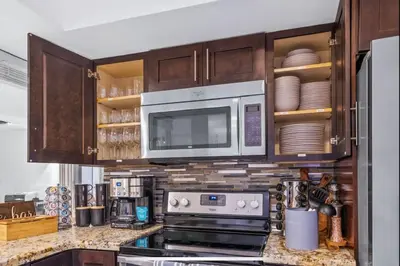 a kitchen with a microwave and a stove top oven at SUN VILLA Heated Pool Near Hard Rock & Beach in Hollywood