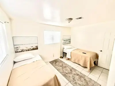 a white room with two beds and a window at Better Experience Property in Miramar