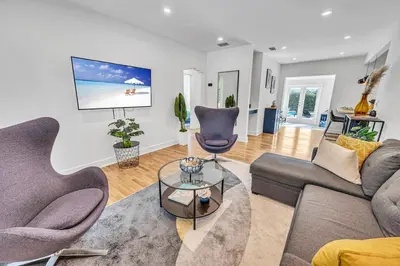 a living room with two couches and a table at The Design District Pool House in Miami