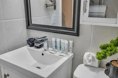 a bathroom with a sink and a mirror and a toilet at Blue Heaven Poolside Retreat Brickell Sleeps 13 in Miami