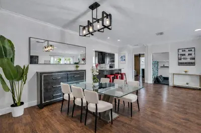a dining room with a glass table and chairs at Blue Heaven Poolside Retreat Brickell Sleeps 13 in Miami