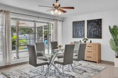 a dining room with a glass table and chairs at The Blue Heaven Private Pool Hideaway Sleeps 11 in Golden Glades