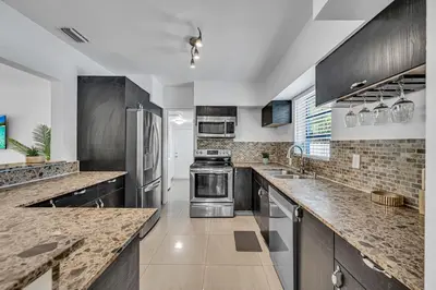 a kitchen with stainless steel appliances and marble counter tops at The Blue Heaven Private Pool Hideaway Sleeps 11 in Golden Glades