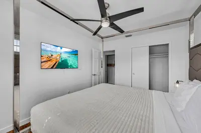 a bedroom with a white bed and a ceiling fan at The Blue Heaven Private Pool Hideaway Sleeps 11 in Golden Glades