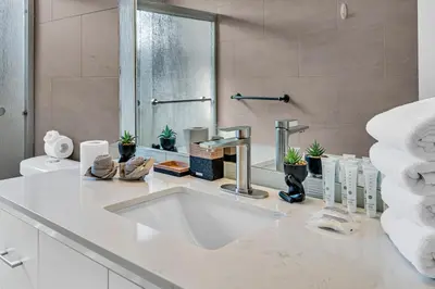 a white bathroom with a sink and a shower at The Blue Heaven Private Pool Hideaway Sleeps 11 in Golden Glades