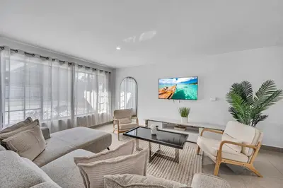a living room with a couch and a table at The Blue Heaven Private Pool Hideaway Sleeps 11 in Golden Glades