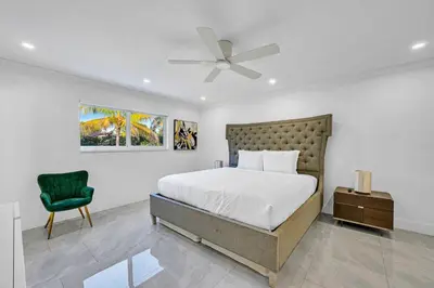 a bedroom with a bed and a green chair at Casa Sol in Richmond Heights