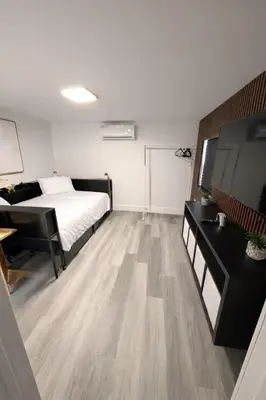 a bedroom with a bed and a desk and a television at PrimeStay Modern Studio in Prime Location in Hollywood