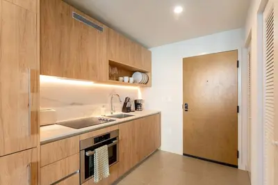 a kitchen with wooden cabinets and a sink and a door at Crosby Miami WTC 1BR 1BA Chic Flawless New #2913 in Miami