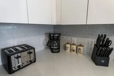 a kitchen counter with a stove and a coffee maker at Coastal 2BR-2BA Oasis Beach Pool Parking EV Estation in Hallandale Beach
