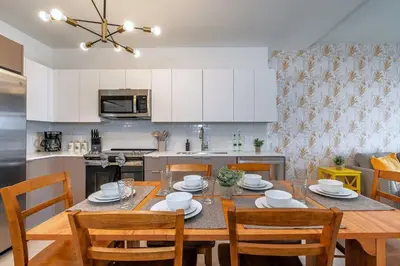 a kitchen and dining room with a table and chairs at Coastal 2BR-2BA Oasis Beach Pool Parking EV Estation in Hallandale Beach