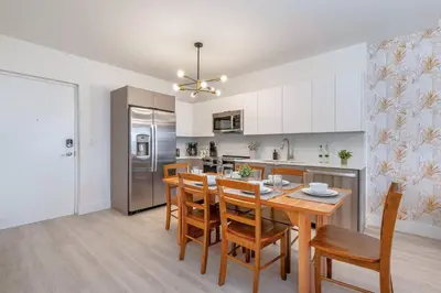 a kitchen and dining room with a table and chairs at Coastal 2BR-2BA Oasis Beach Pool Parking EV Estation in Hallandale Beach