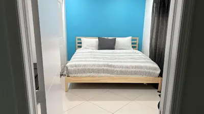 a bedroom with a bed with a blue wall at Villa la Morada - Live stress-free in fully furnished, all-inclusive corporate housing! in Miami
