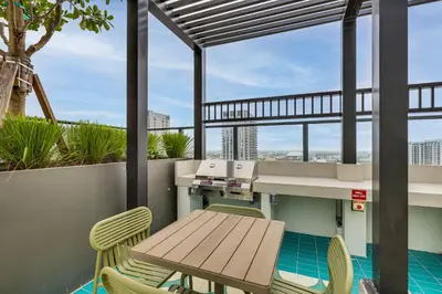 a patio with a wooden table and chairs on a balcony at Luxe High-Rise Living! Crosby Condo with Ocean View in Miami