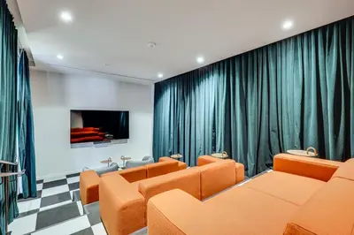 a waiting room with orange chairs and a flat screen tv at Luxe High-Rise Living! Crosby Condo with Ocean View in Miami