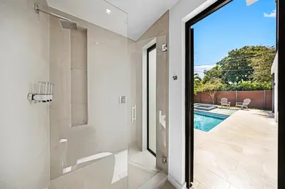 a bathroom with a shower and a swimming pool at Up to 10 Guests! Design District Villa in Miami