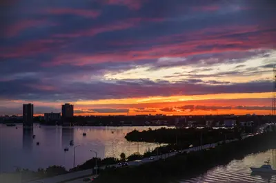 a sunset over a body of water with a city at Penthouse 1BR Miami Beach, amazing Ocean and Skyline views in Miami Beach