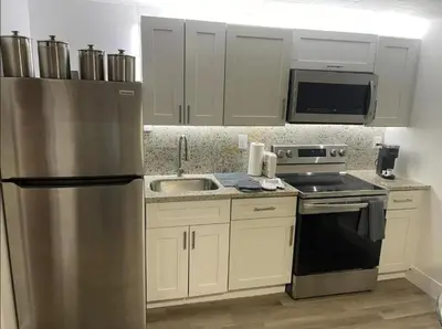 a kitchen with a stainless steel refrigerator and a sink at Comfort Apartment Miramar in Miramar