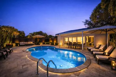 a swimming pool with lounge chairs and a house at The Rose By Brikell in Miami