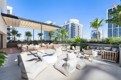 a patio with white chairs and tables and buildings at Luxury Urban Comfort at The Crosby Miami - Central Location in Miami