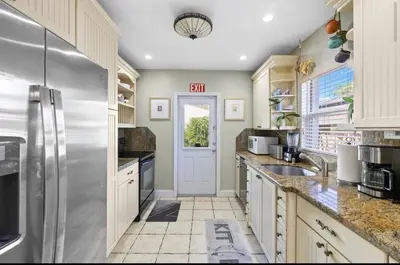 a kitchen with white cabinets and a refrigerator at Coconut Villa in Hollywood