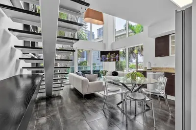 a living room with a glass table and chairs at Urban Oasis 2BR Loft Residence in Brickell in Miami