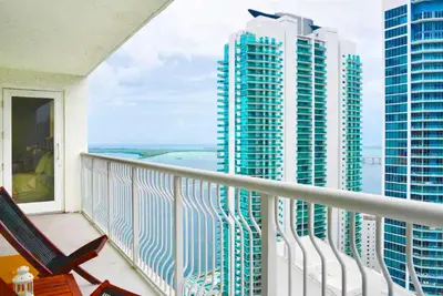 a balcony with chairs and a view of tall buildings at Poolside Brickell Gem Stay in Miami
