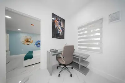 a bedroom with a desk and a bed and a chair at Villa Shallat in Miami