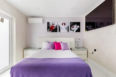 a bedroom with a large bed with purple sheets at Villa Shallat in Miami