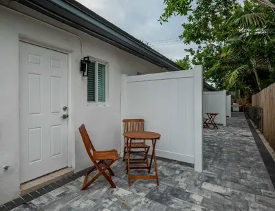 a patio with two chairs and a white fence at Walkable 1BR Apt near Las Olas - Fast WiFi & AC in Fort Lauderdale