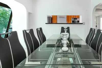 a dining room with a glass table and chairs at Aventura Lakefront in Miami