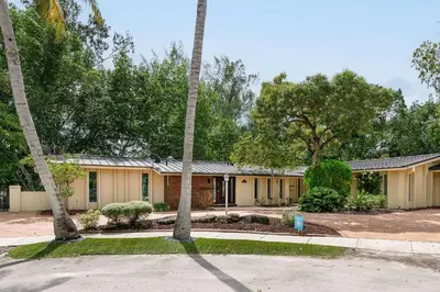 a house with two palm trees in front of it at Aventura Lakefront in Miami