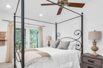 a bedroom with a black and white bed and a ceiling fan at Aventura Lakefront in Miami