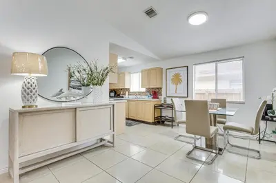 a kitchen and dining room with a table and chairs at Walk to The Big Easy Casino Cozy Apt Near Beaches in Hallandale Beach