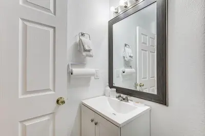 a white bathroom with a sink and a mirror at Walk to The Big Easy Casino Cozy Apt Near Beaches in Hallandale Beach