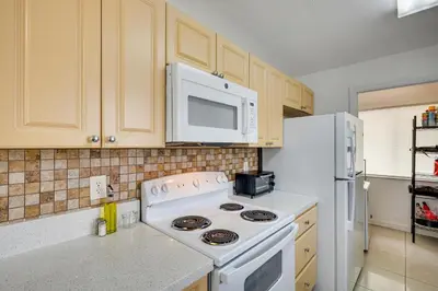 a kitchen with a white stove and a microwave at Walk to The Big Easy Casino Cozy Apt Near Beaches in Hallandale Beach