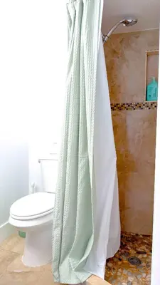 a bathroom with a toilet and a shower curtain at Lazy Cabana- Pool Canal Wilton Drive in Fort Lauderdale