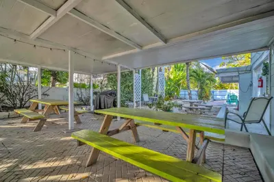 two picnic tables and a bench on a patio at Lazy Cabana- Pool Canal Wilton Drive in Fort Lauderdale
