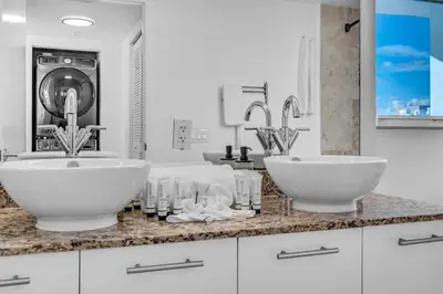 a bathroom with two sinks and a washing machine at Luxury 2BD Corner Loft with Stunning Miami River View in Miami