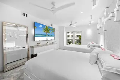 a white bedroom with two beds and a bath tub at Versace Mansion Neighbor (Floors 2 & 3) Sleeps 12 in Miami Beach