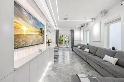 a living room with a couch and a large painting on the wall at Versace Mansion Neighbor (Floor 1) Sleeps 9 in Miami Beach