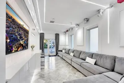 a living room with a couch and a painting on the wall at Versace Mansion Neighbor (Floor 1) Sleeps 9 in Miami Beach
