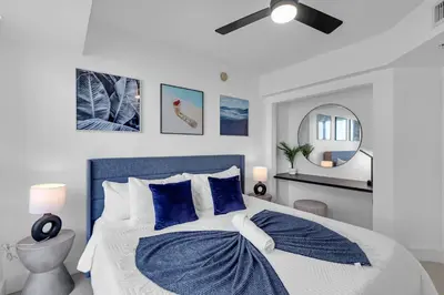 a bedroom with a blue and white bed with blue pillows at Brickell Residence 2BR Loft with amazing views in Miami