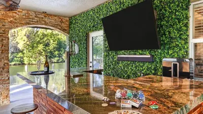 a kitchen with a counter with a tv on the wall at Riverside Veranda by AvantStay Waterfront Stay Infinity Pool Private Dock Easy Beach Access in Dania Beach