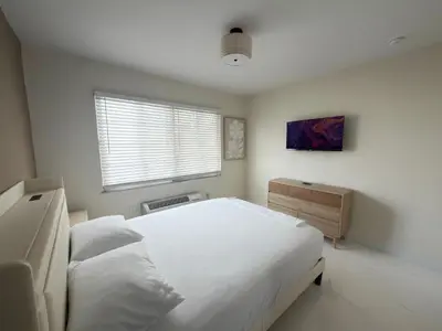a bedroom with a large white bed and a window at MB Playa Hotel & Apartments in Miami Beach