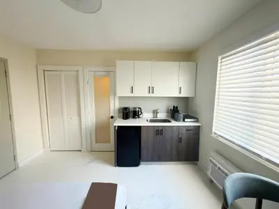 a kitchen with white cabinets and a sink at MB Playa Hotel & Apartments in Miami Beach