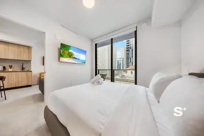 a white bedroom with a large bed and a large window at Downtown Miami Cozy Retreat with Views in Miami